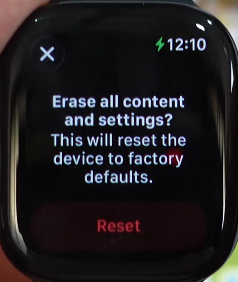 Image showing apple watch screen with red reset button on it.