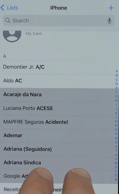 Multiple contacts highlighted in gray on iPhone with double fingers drag.