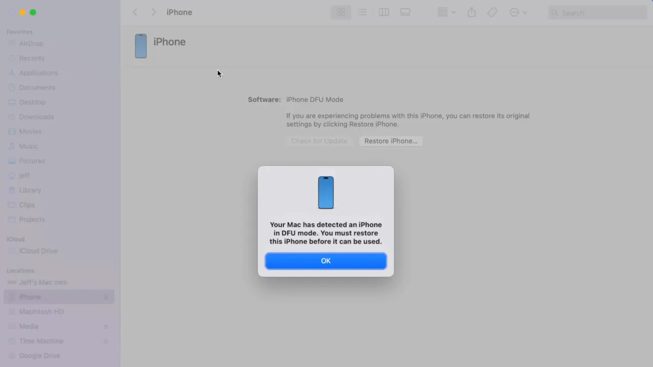 iPhone in DFU Mode with black screen connected to computer showing recovery alert on Mac.