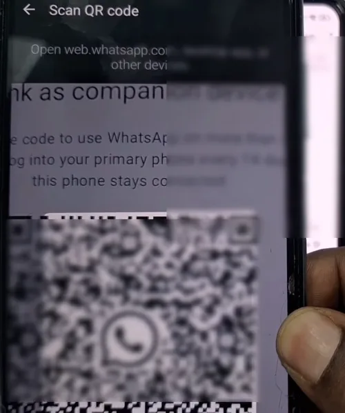 Scanning QR code on main phone from secondary device to link WhatsApp.