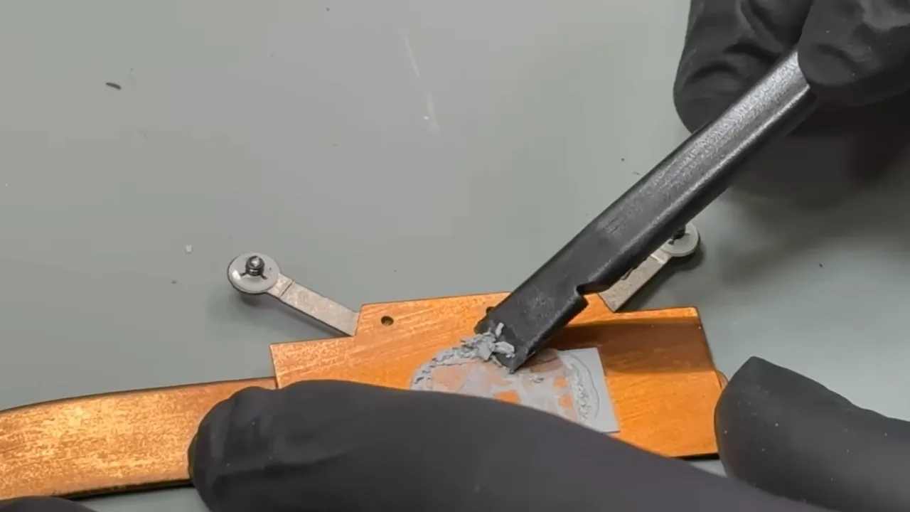 A person cleaning thermal paste from heat sink copper plate.