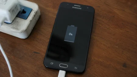 Android phone plugged into charger not charging showing 0 percent battery on screen.