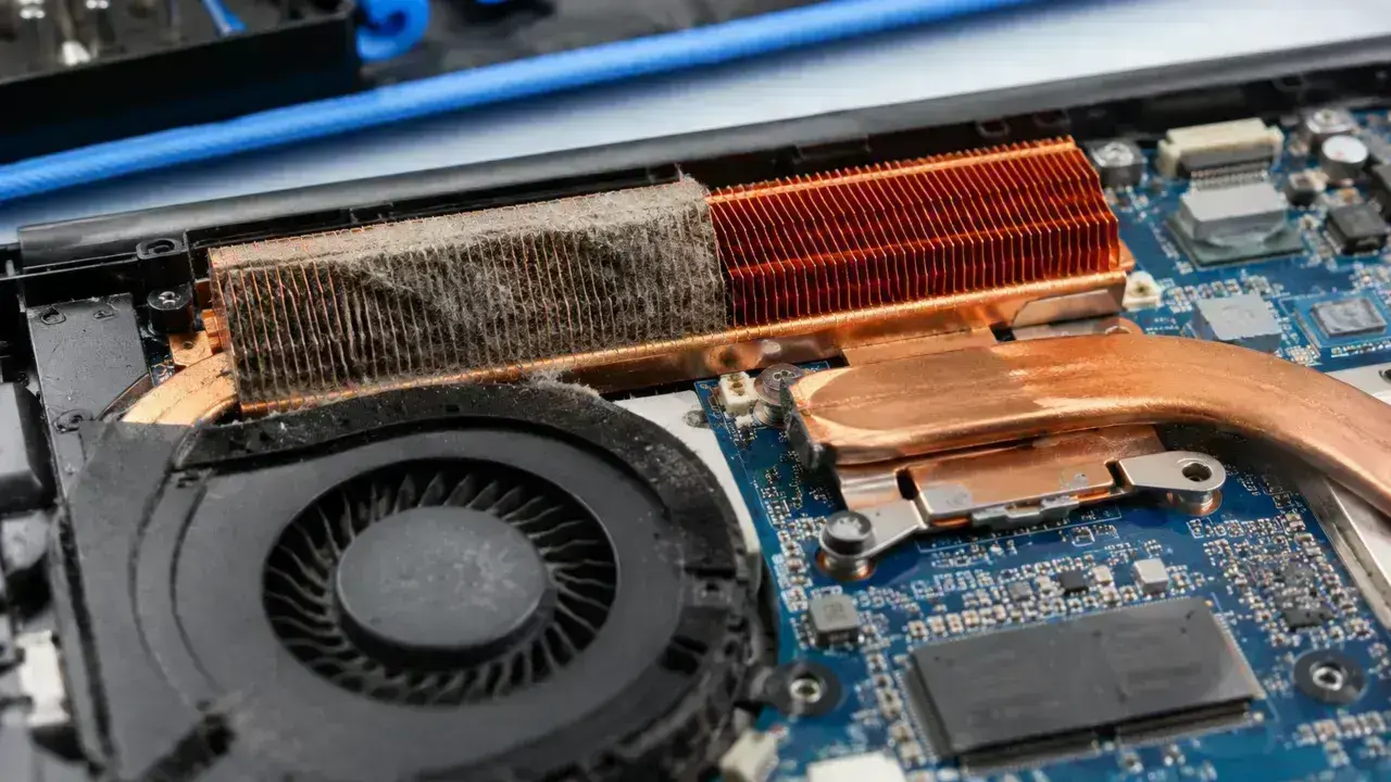 Dust and pet hair clogging laptop heatsink fins beside a clean cooling fin stack.